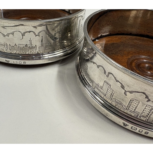 447 - A fine pair of silver coasters with engraved skyline scenes. London 1970. By CJ Vander. Approx. 430 ... 