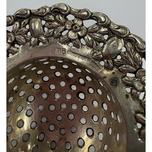 51 - A Continental silver tea strainer with chased decoration. Approx. 57 grams. Est. £40 - £60.