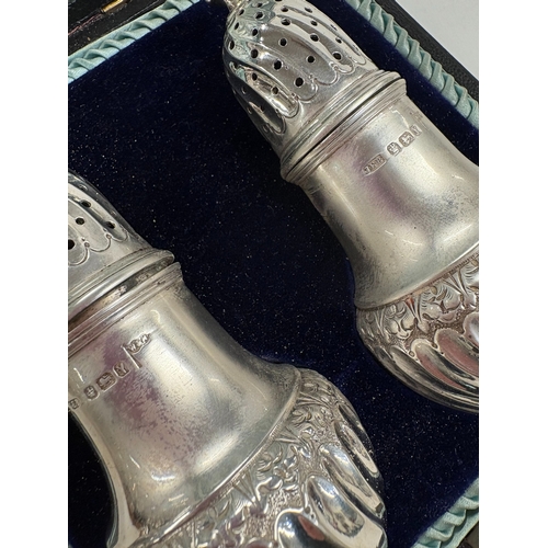 525 - A cased pair of silver casters. Sheffield. Approx. 148 grams. Est. £100 - £150.