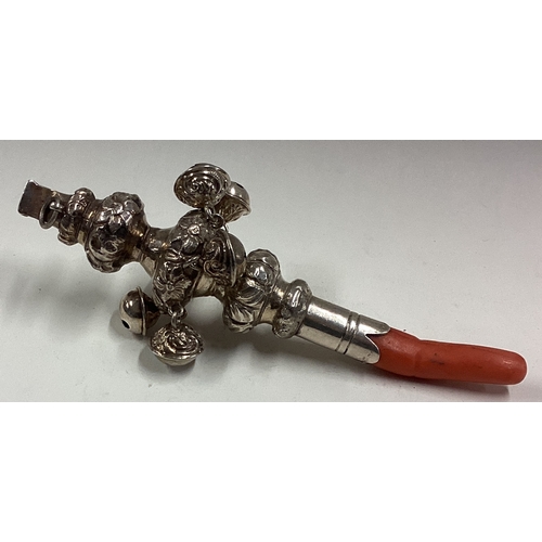 572 - A chased 19th Century William IV silver rattle with bells and coral handle. Approx. 44 grams. Est. £... 