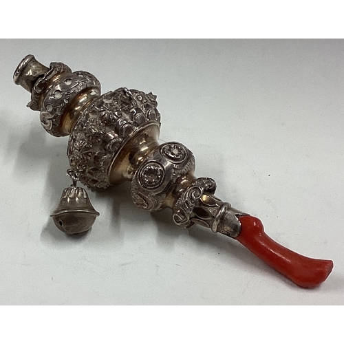 573 - A chased Victorian silver rattle with coral handle. Approx. 58 grams. Est. £150 - £200.