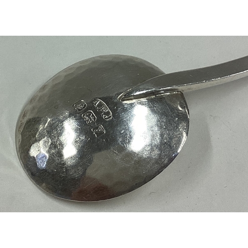 619 - A E JONES: A large cast silver preserve spoon with textured decoration. Approx. 25 grams. Est. £60 -... 