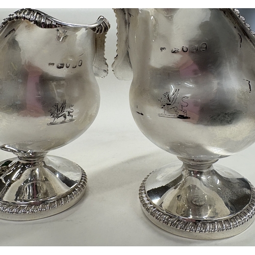 650 - A clean pair of George III silver sauceboats with shell border and crested decoration. London 1801. ... 