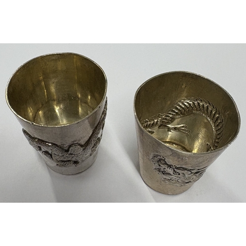 666 - A pair of Chinese export silver stacking beakers embossed with dragon decoration. Approx. 52 grams. ... 