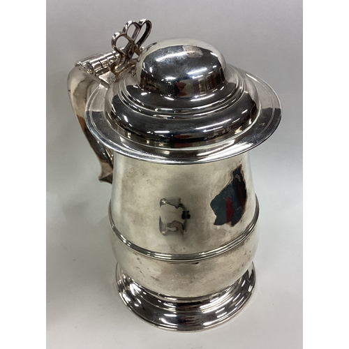 671 - A Georgian silver baluster-shaped tankard with hinged cover. London. By EV. Approx. 801 grams. Est. ... 