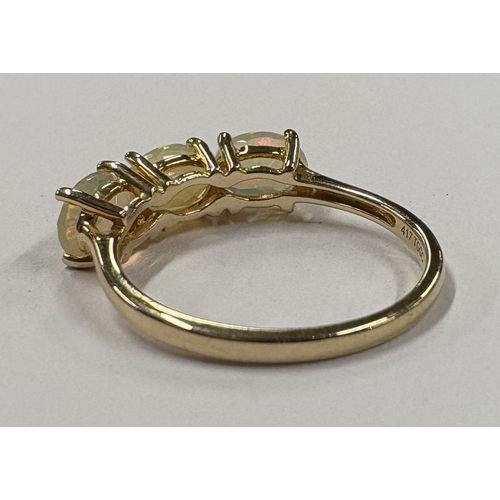 719 - A 10 carat three-stone ring in claw mount. Approx. ring size P 1/2. Approx. 2 grams. Est. £40 - £60.