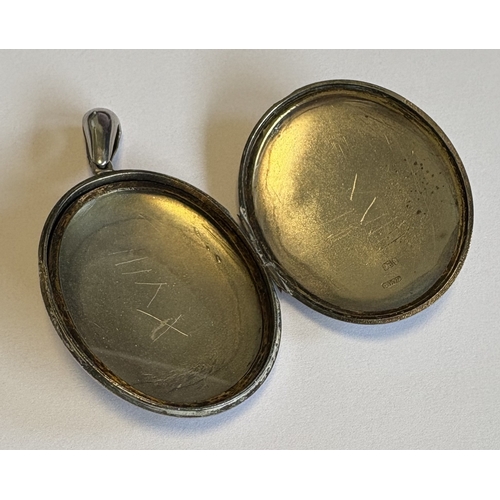 738 - A large oval silver hinged-top locket with floral decoration. Approx. 25 grams. Est. £30 - £50.