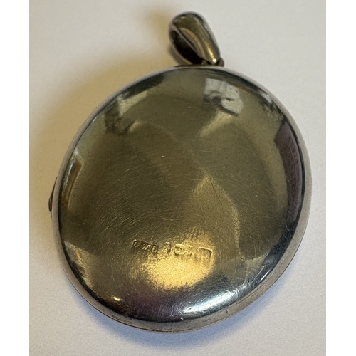 738 - A large oval silver hinged-top locket with floral decoration. Approx. 25 grams. Est. £30 - £50.