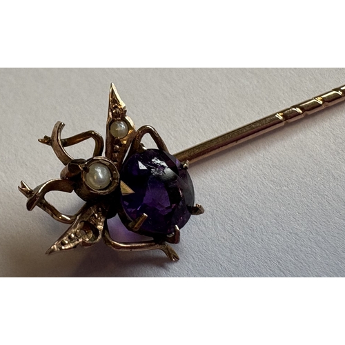 763 - A gold and amethyst stick pin. Approx. 1 gram. Est. £20 - £30.