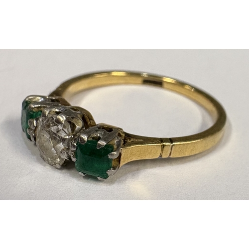 795 - A good emerald and diamond three-stone ring set in two-colour gold. Approx. ring size S. Approx. 3 g... 