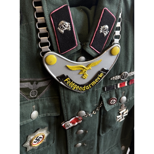 158 - A reproduction WW2 German Feldgendarmerie uniform together with a helmet and gas mask case. Est. £20... 