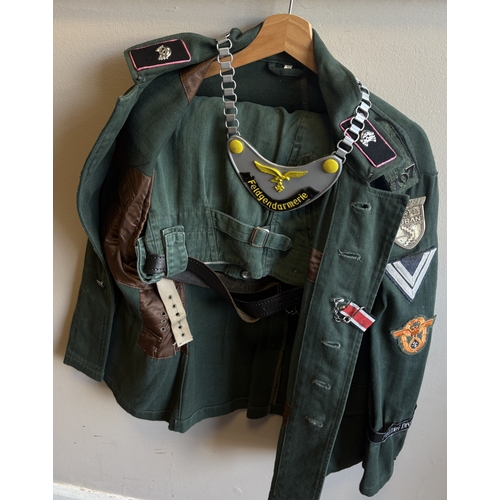 158 - A reproduction WW2 German Feldgendarmerie uniform together with a helmet and gas mask case. Est. £20... 