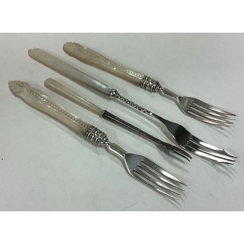 164 - A group of four silver-mounted pickle forks with MOP handles. Approx. 78 grams. Est. £20 - £30.
