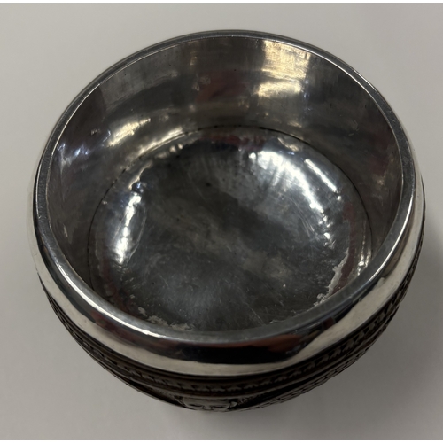174 - A rare 19th Century Indian silver-mounted coconut cup carved with elephant decoration on ball feet. ... 