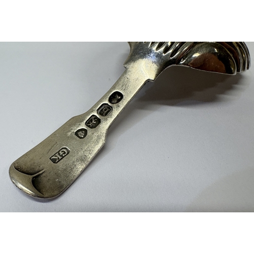 24 - A Georgian silver caddy spoon with fluted decoration. London 1823. Approx. 14 grams. Est. £40 - £60.