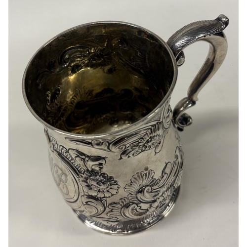 36 - A large 18th Century embossed silver pint mug. London 1746. Approx. 362 grams. Est. £300 - £400.