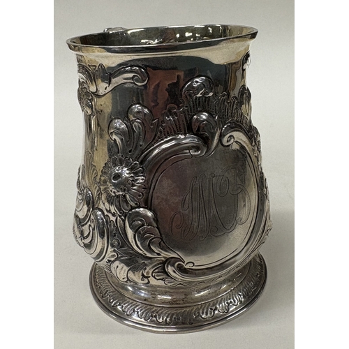 36 - A large 18th Century embossed silver pint mug. London 1746. Approx. 362 grams. Est. £300 - £400.