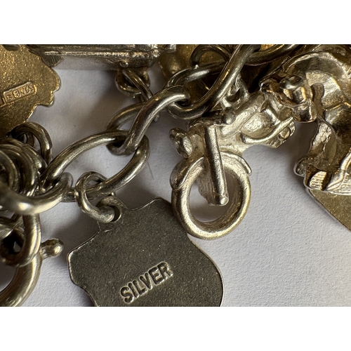 42 - A heavy silver curb link charm bracelet. Approx. 70 grams. Est. £40 - £60.