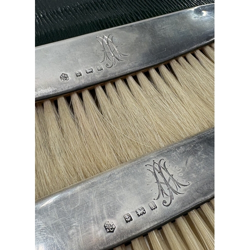 197 - A pair of silver-mounted crumb brushes contained within original pouch. Birmingham 1910. By SB & Co.... 