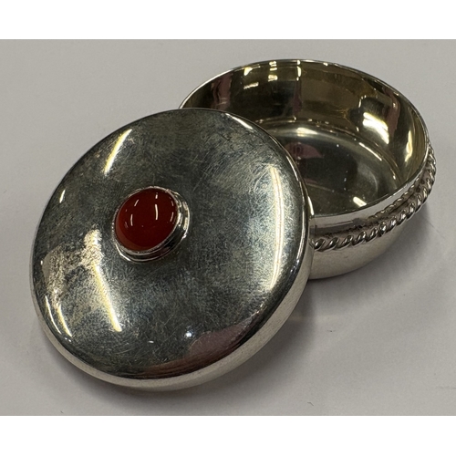 422 - A silver snuff box with lift-off cover decorated with red stone, engraved with bee decoration to bas... 