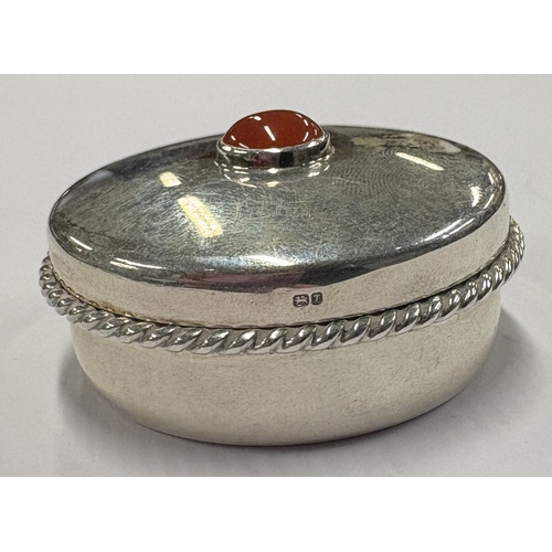 422 - A silver snuff box with lift-off cover decorated with red stone, engraved with bee decoration to bas... 