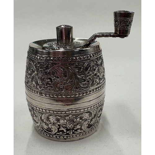 564 - A silver-plated pepper grinder with chased decoration. Est. £20 - £30.