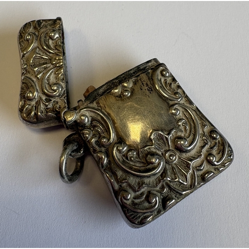 582 - A chased silver vesta case with loop top. Approx. 20 grams. Est. £20 - £30.