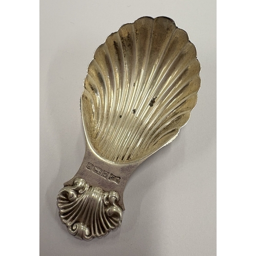 586 - A silver caddy spoon with shell decoration. Birmingham 1989. By Bishton's Ltd. Approx. 19 grams. Est... 