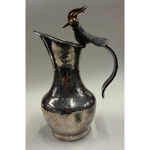 678 - A silver-plated jug with handle in the form of a bird. Est. £30 - £40.