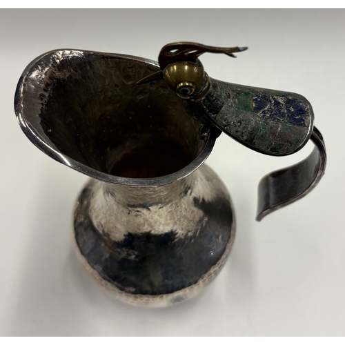 678 - A silver-plated jug with handle in the form of a bird. Est. £30 - £40.