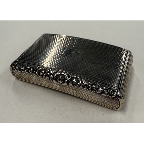 698 - An engine-turned Victorian silver snuff box with chased floral decoration to hinged cover and gilt i... 