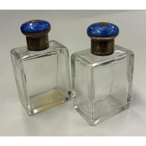 699 - A pair of silver-lidded and blue enamelled glass scent bottles. By George Betjemann & Sons Ltd, reta... 
