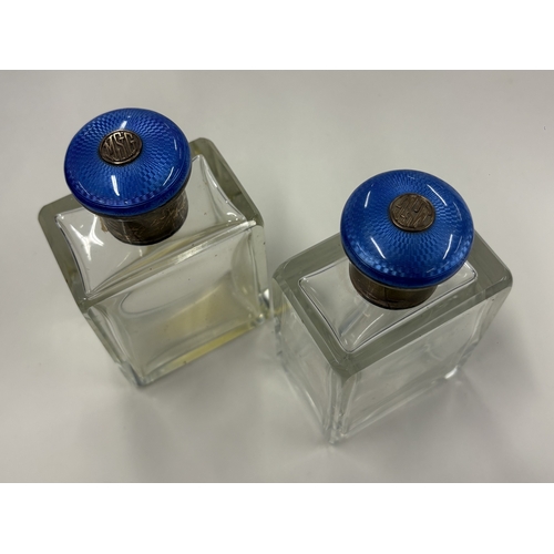 699 - A pair of silver-lidded and blue enamelled glass scent bottles. By George Betjemann & Sons Ltd, reta... 