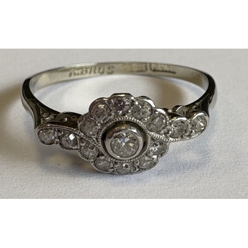 721 - A small diamond daisy-head cluster ring in 18 carat white gold and platinum setting. Approx. 2 grams... 