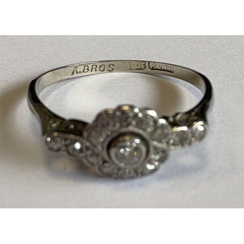 721 - A small diamond daisy-head cluster ring in 18 carat white gold and platinum setting. Approx. 2 grams... 