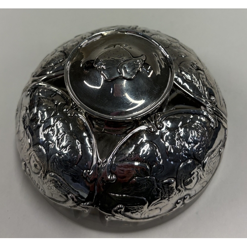 558 - A heavy Victorian silver-mounted glass inkwell chased with cherub decoration. London 1900. By Willia... 