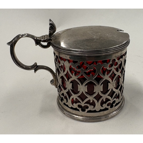 548 - An attractive pierced silver mustard with ruby red glass liner. London. By TG. Approx. 134 grams. Es... 
