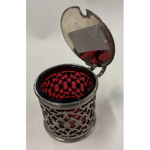 548 - An attractive pierced silver mustard with ruby red glass liner. London. By TG. Approx. 134 grams. Es... 