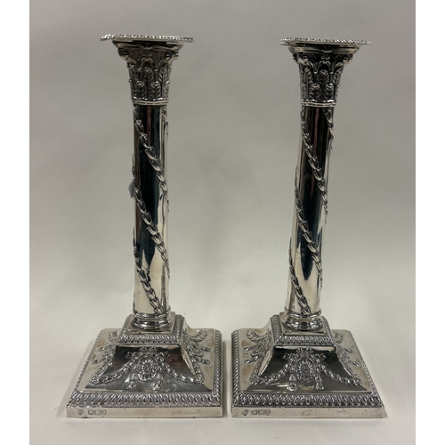 691 - A good pair of silver candlesticks on square bases with gadroon rims. Sheffield 1893. By Hawksworth,... 
