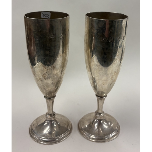 702 - A large pair of tapering silver champagne flutes with gilt interiors. London 1973. By John Henry Ode... 