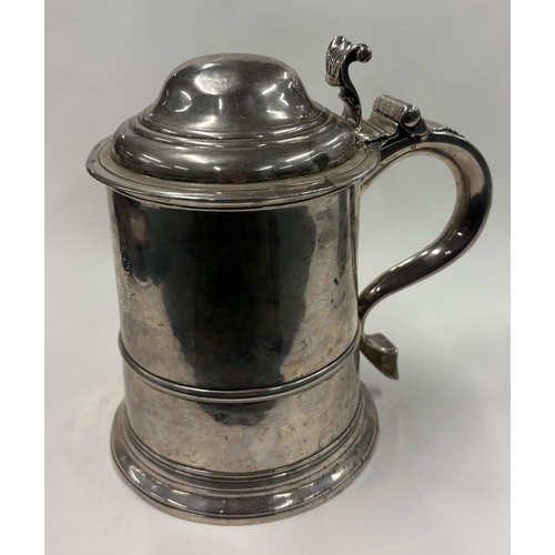 703 - A plain Georgian silver domed-top tankard on reeded base, marked to lid, handle and body. London 173... 