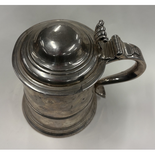 703 - A plain Georgian silver domed-top tankard on reeded base, marked to lid, handle and body. London 173... 