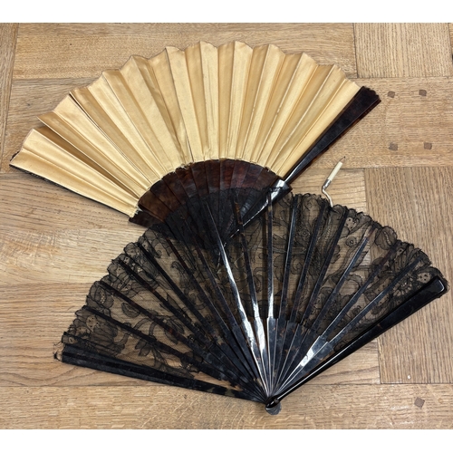 310 - A tortoiseshell and lace fan together with one other. Est. £20 - £30.