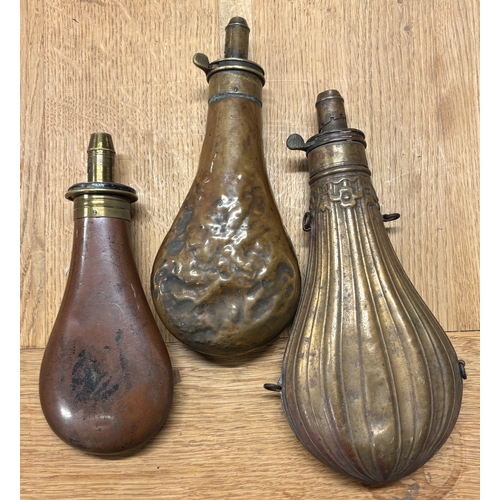 314 - A large fluted shot flask together with two others. Est. £20 - £30.