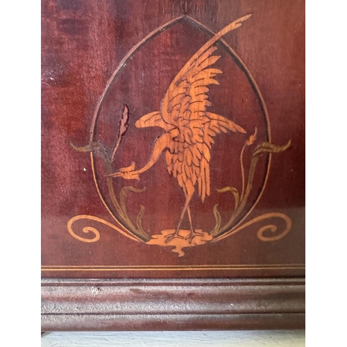 332 - A mahogany shaped mantle clock with brass face and inlaid decoration. Est. £20 - £30.