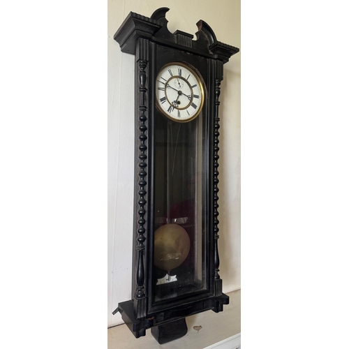 331 - An ebony cased wall clock with white painted dial. Est. £30 - £50.