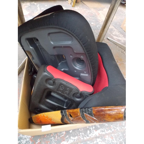 125 - A BOX CONTAINING CHILD'S BOOSTER SEATS, CARVED WOODEN MASK ETC