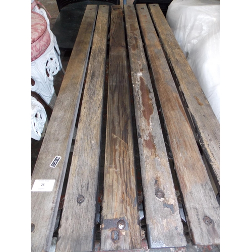 26 - A WOODEN SLATTED GARDEN BENCH WITH ORNATE CAST IRON FEET