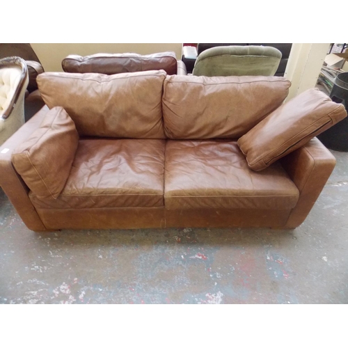 523 - A BROWN LEATHER TWO SEATER SOFA BED