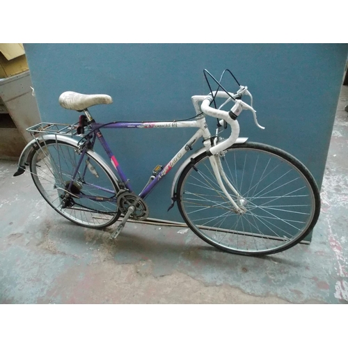 22 - TWO VINTAGE MENS RACING BIKES - ONE MULTI COLOURED MBK WITH 12 SPEED GEAR SYSTEM AND ONE PURPLE AND ... 